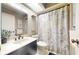 Bathroom featuring a vanity with solid surface countertop, framed mirror and shower with decorative curtain at 64 Pelican Pl, Belleair, FL 33756