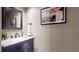 Stylish powder room with a marble vanity top, framed mirror, and a decorative flamingo art print at 64 Pelican Pl, Belleair, FL 33756