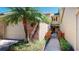 Charming home exterior featuring a brick facade, palm trees, and a gated walkway leading to the front door at 64 Pelican Pl, Belleair, FL 33756