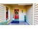 Charming front porch with a red door, sidelight, and a seasonal wreath, creating an inviting entrance at 64 Pelican Pl, Belleair, FL 33756