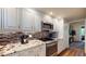 The kitchen features white cabinets, granite countertops, stainless steel appliances, and a tiled backsplash at 64 Pelican Pl, Belleair, FL 33756