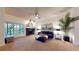 Bright living room featuring a black brick fireplace, neutral carpet, large windows, and modern furniture at 64 Pelican Pl, Belleair, FL 33756