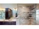 Bright main bathroom featuring double sinks, stunning marble countertops, and glass shower with tiled walls at 64 Pelican Pl, Belleair, FL 33756