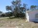 Side of house with lawn and mature trees at 6473 Blackbird Ave, Weeki Wachee, FL 34613