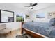 Bright bedroom with a wooden bed frame, large windows, and a ceiling fan on light hardwood flooring at 715 44Th Ne Ave, St Petersburg, FL 33703