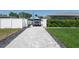 A spacious driveway constructed of pavers extends to the modern home and includes verdant grass at 715 44Th Ne Ave, St Petersburg, FL 33703