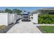 Paver driveway leads to a well maintained house with white fencing and mature landscaping at 715 44Th Ne Ave, St Petersburg, FL 33703