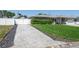 Long paved driveway leading to a well-maintained home with a white fence and lush green lawn at 715 44Th Ne Ave, St Petersburg, FL 33703