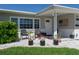 Charming front porch with brick accents, seating area, and flower pots, all enhanced by a well-kept lawn at 715 44Th Ne Ave, St Petersburg, FL 33703