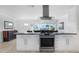 Spacious kitchen features white cabinets, stainless appliances, and a modern island with a cooktop at 715 44Th Ne Ave, St Petersburg, FL 33703