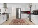 Bright and open kitchen with stainless steel appliances and white cabinetry, centered on decorative area rug at 715 44Th Ne Ave, St Petersburg, FL 33703