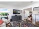 Inviting living room with TV, comfortable seating, and large windows offering natural light, set on hardwood flooring at 715 44Th Ne Ave, St Petersburg, FL 33703