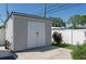 Exterior view of storage shed with double doors and concrete pad in a fenced backyard at 715 44Th Ne Ave, St Petersburg, FL 33703
