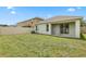 Spacious grass backyard with a patio, white fence, and the home's exterior at 7233 Lumber Port Dr, Ruskin, FL 33573