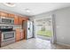 The kitchen offers stainless steel appliances, wood cabinets, tile floor, and sliding glass doors to the yard at 7233 Lumber Port Dr, Ruskin, FL 33573