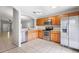 Well-lit kitchen with stainless appliances, wooden cabinets, tile floors, and open layout to the living room at 7233 Lumber Port Dr, Ruskin, FL 33573