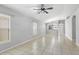 Open living space boasts neutral paint, tiled floor, windows with blinds, and modern ceiling fan at 7233 Lumber Port Dr, Ruskin, FL 33573
