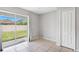 Bright living room featuring tiled flooring, sliding glass doors to the back yard, and a closet for storage at 7233 Lumber Port Dr, Ruskin, FL 33573