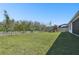 Spacious backyard featuring a green lawn, a white fence, and a wooden playset at 8766 Shadyside Ln, Land O Lakes, FL 34637