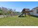 A spacious backyard featuring a playset, a swing, and a well-maintained lawn, perfect for outdoor activities and Gathering fun at 8766 Shadyside Ln, Land O Lakes, FL 34637