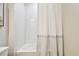 Clean bathroom with white subway tile, bathtub, and shower featuring a striped curtain at 8766 Shadyside Ln, Land O Lakes, FL 34637