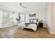 Bright bedroom with tray ceiling, wood floors, plantation shutters and stylish furnishings at 8766 Shadyside Ln, Land O Lakes, FL 34637