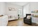 Cozy Bedroom with a white crib, art prints, wood floors, chair and organized bookshelves at 8766 Shadyside Ln, Land O Lakes, FL 34637