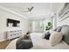 Comfortable bedroom with tray ceiling, TV, white storage cabinet and cozy decor at 8766 Shadyside Ln, Land O Lakes, FL 34637