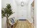 Bright foyer with wood-look floors, a modern light fixture, and a decorative tree beside a bench at 8766 Shadyside Ln, Land O Lakes, FL 34637