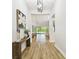 Foyer featuring wood-look flooring, modern lighting, and a view into the open-concept living area at 8766 Shadyside Ln, Land O Lakes, FL 34637