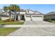 Inviting two-story home with a three-car garage and well-manicured landscaping at 8766 Shadyside Ln, Land O Lakes, FL 34637