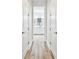 Hallway view of a bathroom with white cabinets, lighting and plank flooring at 8766 Shadyside Ln, Land O Lakes, FL 34637