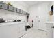 Functional laundry room with washer, dryer, sink, and ample storage shelving at 8766 Shadyside Ln, Land O Lakes, FL 34637