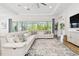 Bright living room with a plush sofa, large windows, and a view of the outdoor greenery, offering a serene ambiance at 8766 Shadyside Ln, Land O Lakes, FL 34637
