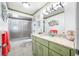 Well-lit bathroom with an olive green vanity, granite countertops, and tiled flooring, next to a shower at 119 13Th Ave, Indian Rocks Beach, FL 33785