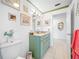 Bright bathroom features a green vanity with granite counters and tiled floors, decorated with unique artwork at 119 13Th Ave, Indian Rocks Beach, FL 33785