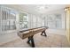 Bright sunroom with multiple windows, a tiled floor, and a shuffleboard table for entertaining at 119 13Th Ave, Indian Rocks Beach, FL 33785