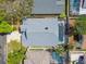 An aerial view of a well-maintained home with a screened-in pool and patio area, surrounded by lush greenery and other homes at 1210 Paradise Lake Dr, Tarpon Springs, FL 34689