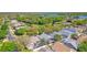 Aerial view captures homes with screened pools, lush greenery, and a serene lake in the backdrop for a relaxed lifestyle at 1210 Paradise Lake Dr, Tarpon Springs, FL 34689