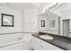 Bathroom with a Jacuzzi tub, a vanity with black counters and framed mirror at 1210 Paradise Lake Dr, Tarpon Springs, FL 34689