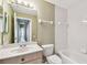 Neutral toned bathroom featuring a vanity, toilet, and bathtub with tiled wall surround and shower fixture at 1210 Paradise Lake Dr, Tarpon Springs, FL 34689