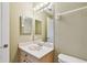 Neutral-toned bathroom featuring a vanity, toilet, and framed mirror with decorative vanity lighting at 1210 Paradise Lake Dr, Tarpon Springs, FL 34689
