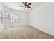 Spacious bedroom with neutral carpet and natural light from multiple windows at 1210 Paradise Lake Dr, Tarpon Springs, FL 34689