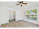 Bedroom with neutral carpet, a ceiling fan, and a doorway leading to another room at 1210 Paradise Lake Dr, Tarpon Springs, FL 34689