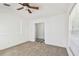 Bedroom featuring neutral carpet, white walls, and a ceiling fan, offering a clean and bright space at 1210 Paradise Lake Dr, Tarpon Springs, FL 34689