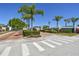 Gated North Lake community entrance with palm trees and brick-paved road, providing security and a welcoming atmosphere at 1210 Paradise Lake Dr, Tarpon Springs, FL 34689