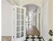 Elegant foyer featuring black and white tile flooring, a coat closet, and arched doorways at 1210 Paradise Lake Dr, Tarpon Springs, FL 34689