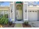 Inviting front entrance with decorative lighting, potted plants, and a security system sign at 1210 Paradise Lake Dr, Tarpon Springs, FL 34689