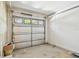 A residential garage with a garage door in need of maintenance, visible concrete floor, and white painted walls at 1210 Paradise Lake Dr, Tarpon Springs, FL 34689