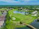 Breathtaking aerial view of the lush golf course, pond, and surrounding community at 1210 Paradise Lake Dr, Tarpon Springs, FL 34689